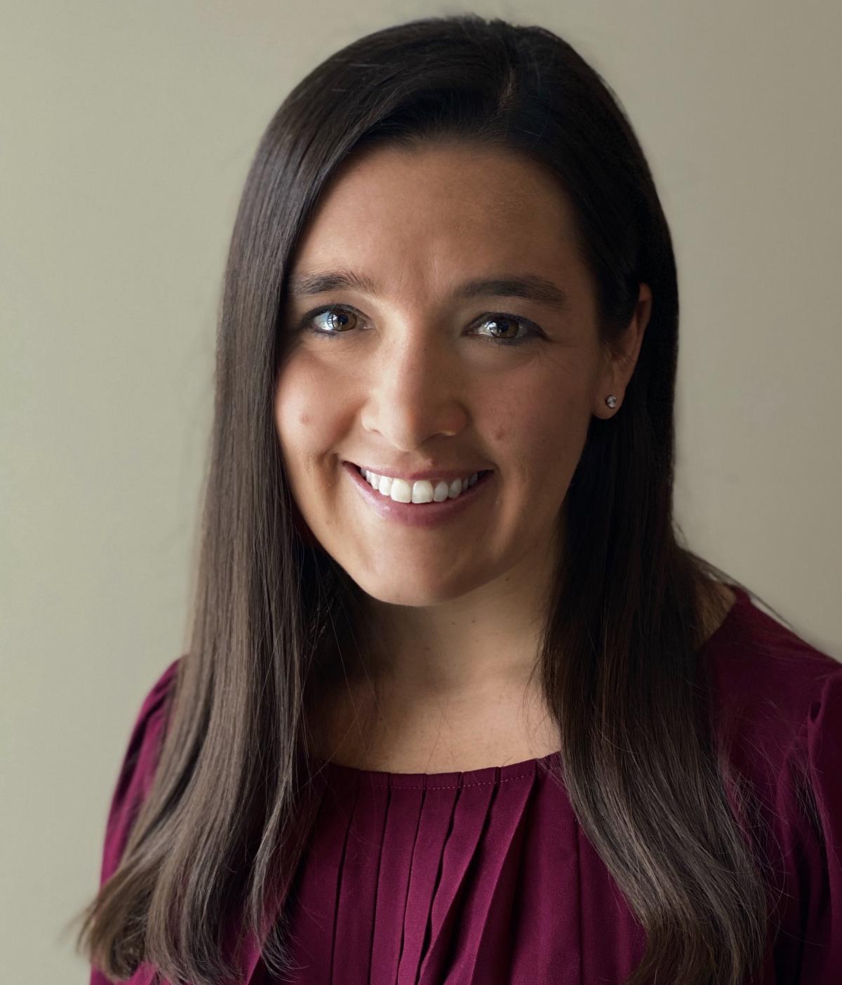 Kristin Wenger headshot: a smiling woman with long, brown hair and a purple shirt